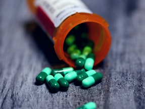 shallow focus photography of prescription bottle with capsules