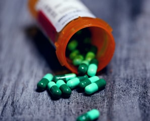 shallow focus photography of prescription bottle with capsules
