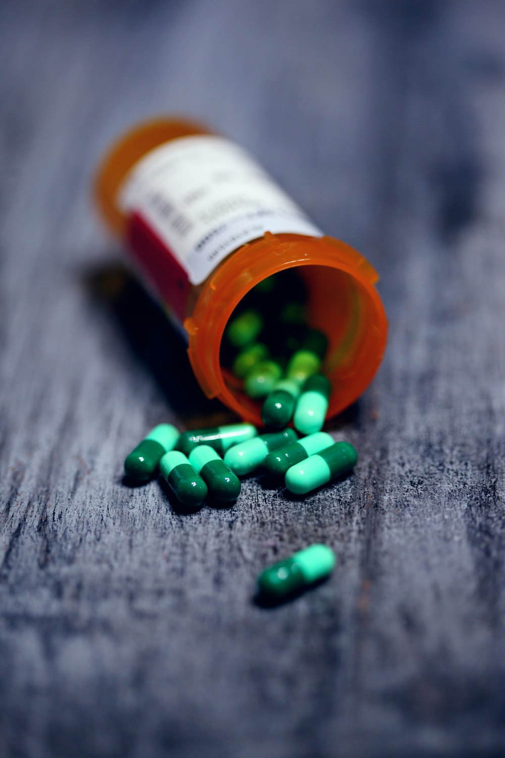 shallow focus photography of prescription bottle with capsules
