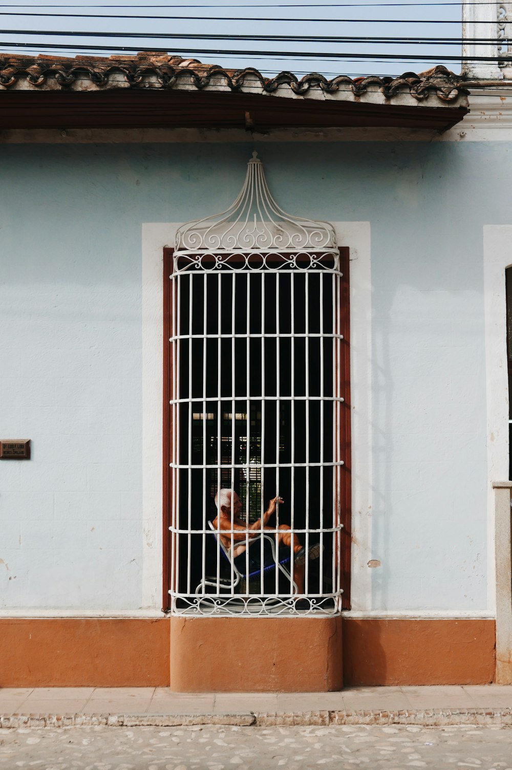 person sitting on rocking chair beside window