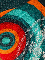 A vibrant quilt binding in progress, showing the final touches that bring the project together.