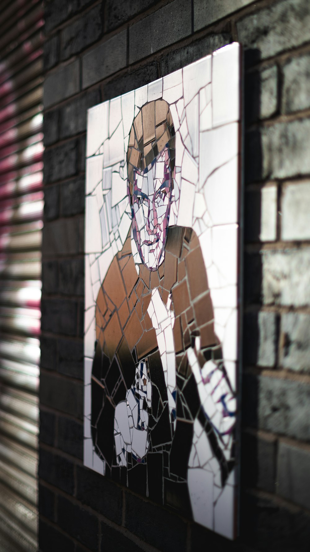 man pointing a gun broken glass painting on brick wall