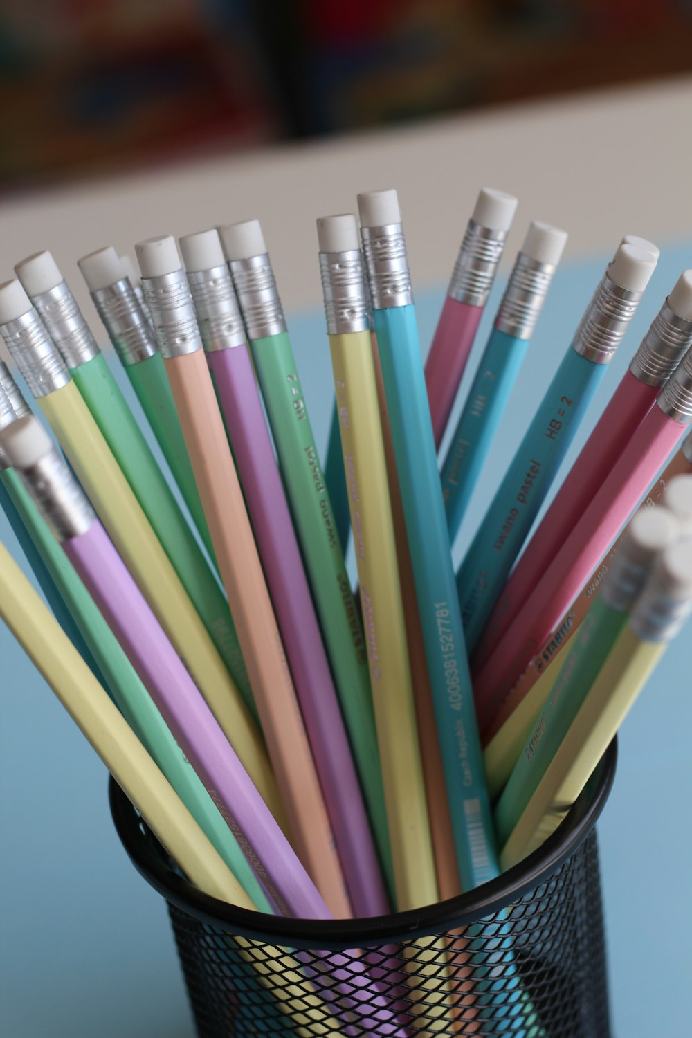 assorted-color wooden pencils on black mesh organizer