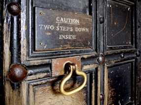 A warm, inviting old wooden door with a small brass nameplate reading 'First Step Carers'.