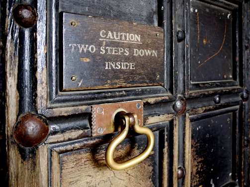 A warm, inviting old wooden door with a small brass nameplate reading 'First Step Carers'.