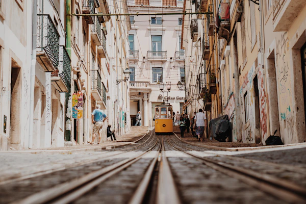 Historic funicular climbing between buildings on a steep Lisbon street