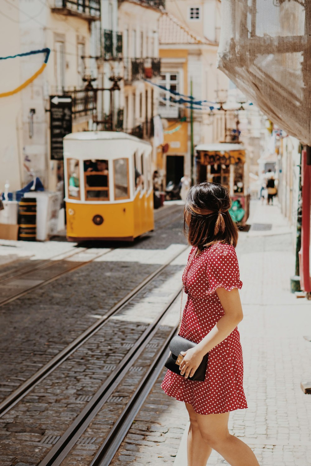 donna che attraversa la strada vicino ai treni a fune