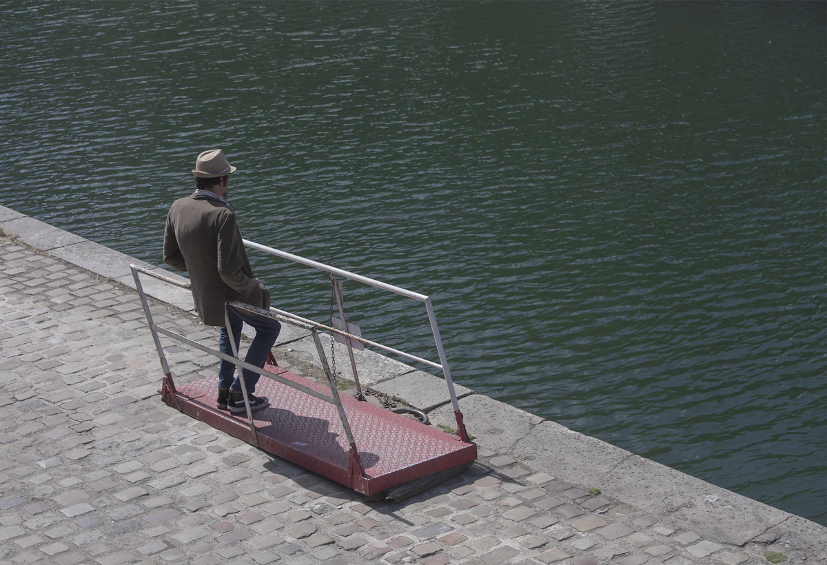Man leaning on railings in thought