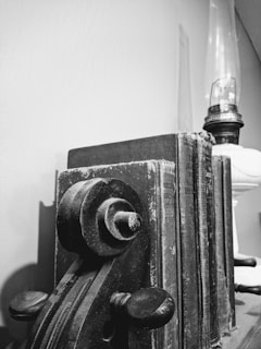 Close-up of a handcrafted metal bookend holding vintage books on a wooden shelf.