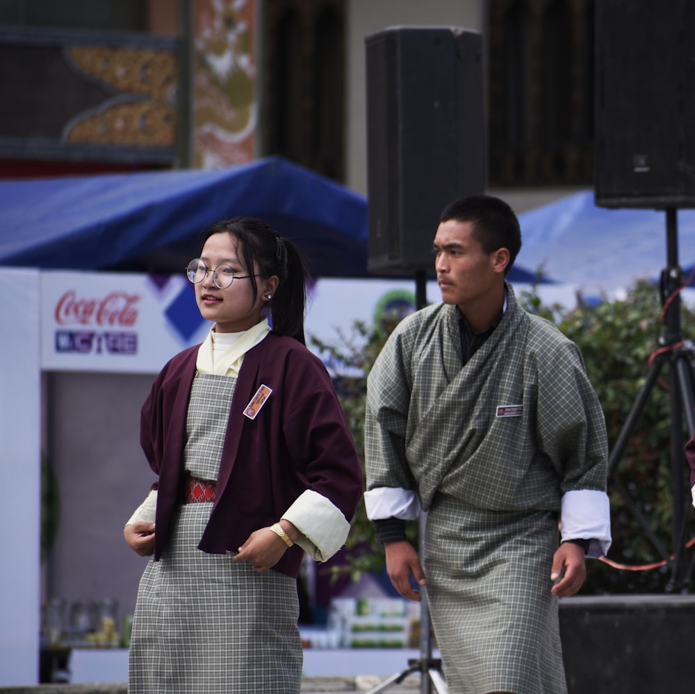 man and woman standing near Coca-Cola booth