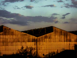 Aerial shot of the export warehouse at dusk, illuminated with warm lighting against a dark green and black backdrop.