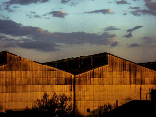 Exterior view of the warehouse building at dusk with company signage visible under soft lighting.