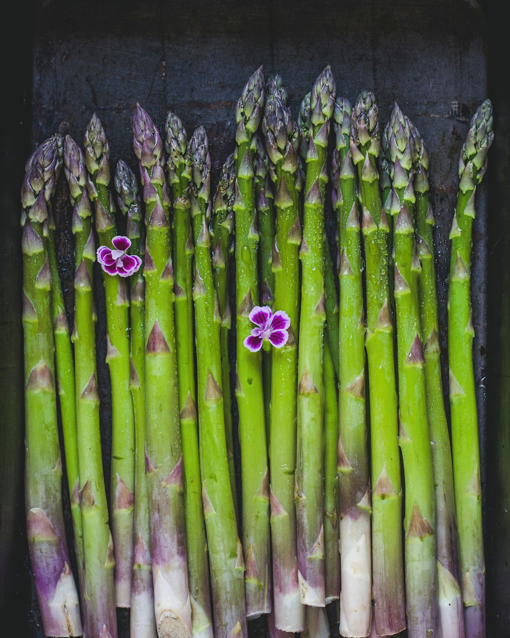 a bunch of asparagus with purple flowers on them