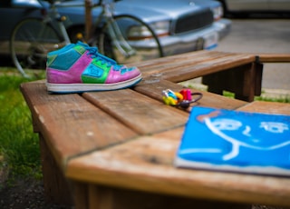 pink and teal high-top sneaker near blue softbound book