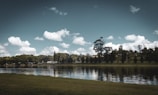 A serene landscape with a calm lake reflecting the sky.