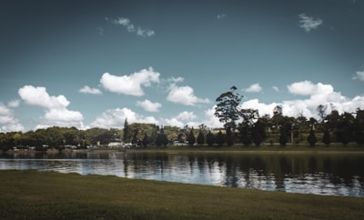 A serene landscape with a calm lake reflecting the sky.