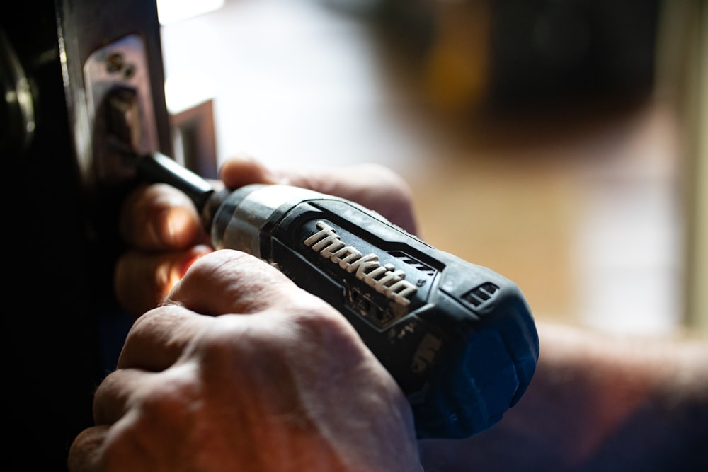 fotografia de foco seletivo azul e preto Makita power drill