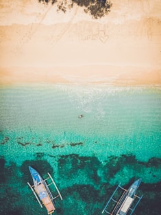 aerial photography of seashore with two boatd