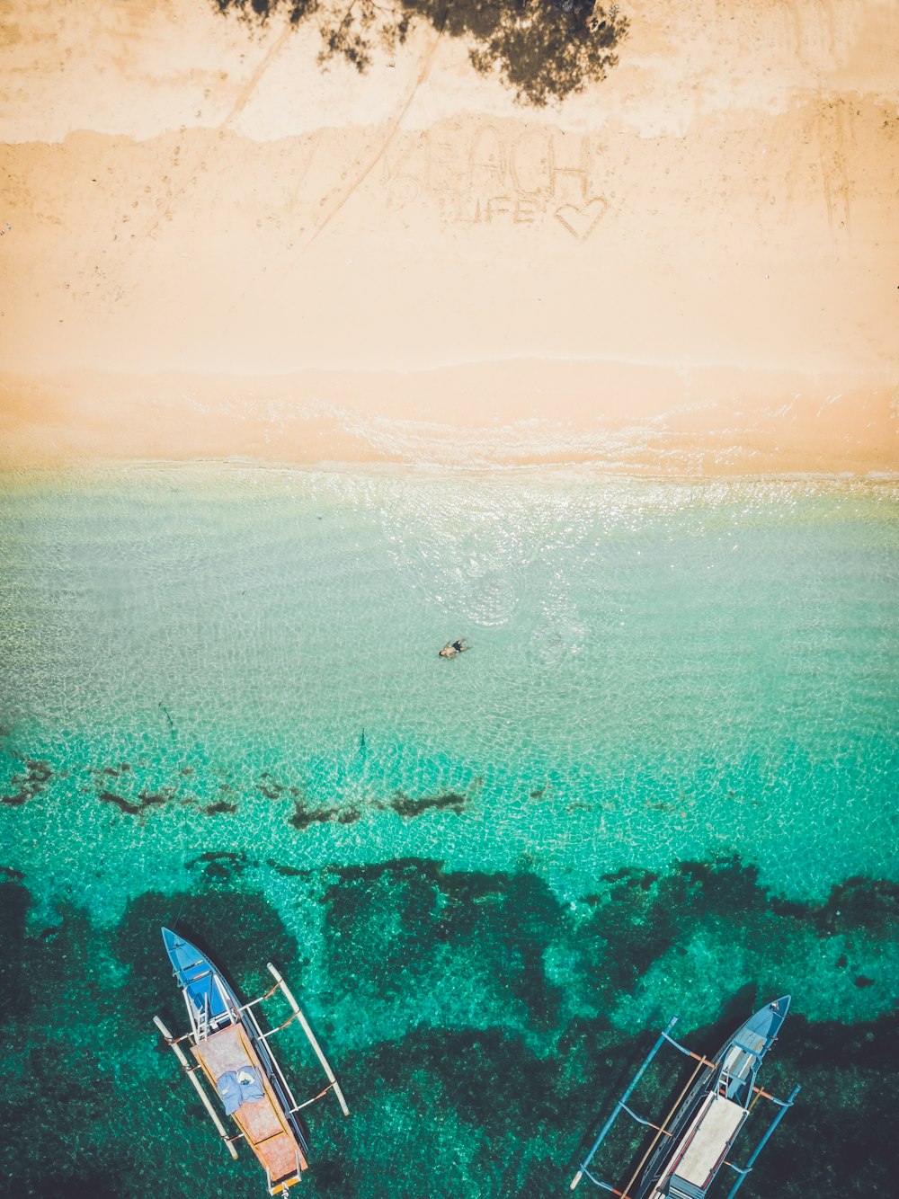 Fotografía aérea de la orilla del mar con dos barcos