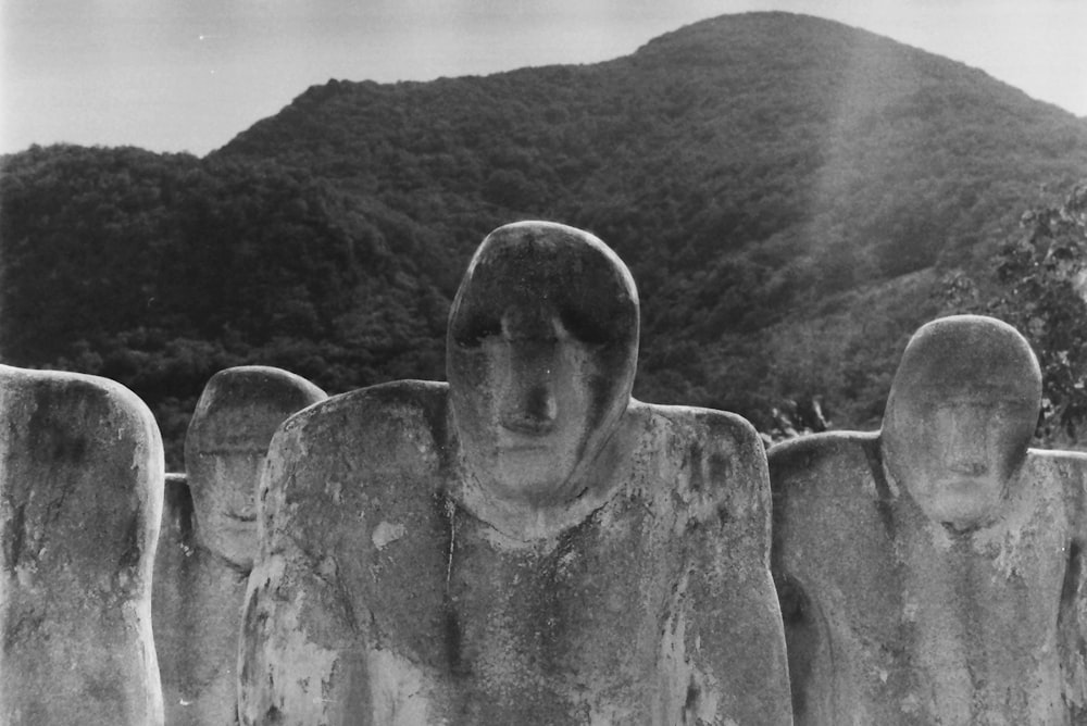 grayscale photography of statues near mountain
