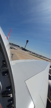 View of a plane landing at Munich Airport with a clear sky background.