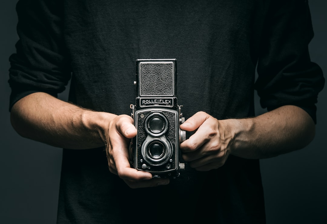 man holding vintage 2-lens camera