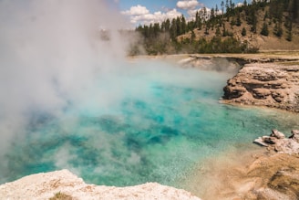 Hot water tinaja steaming under a clear blue sky.