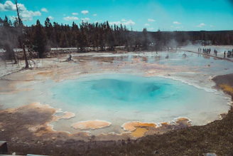 The vibrant turquoise waters of Yellowstone’s Grand Prismatic Spring surrounded by colorful mineral deposits.