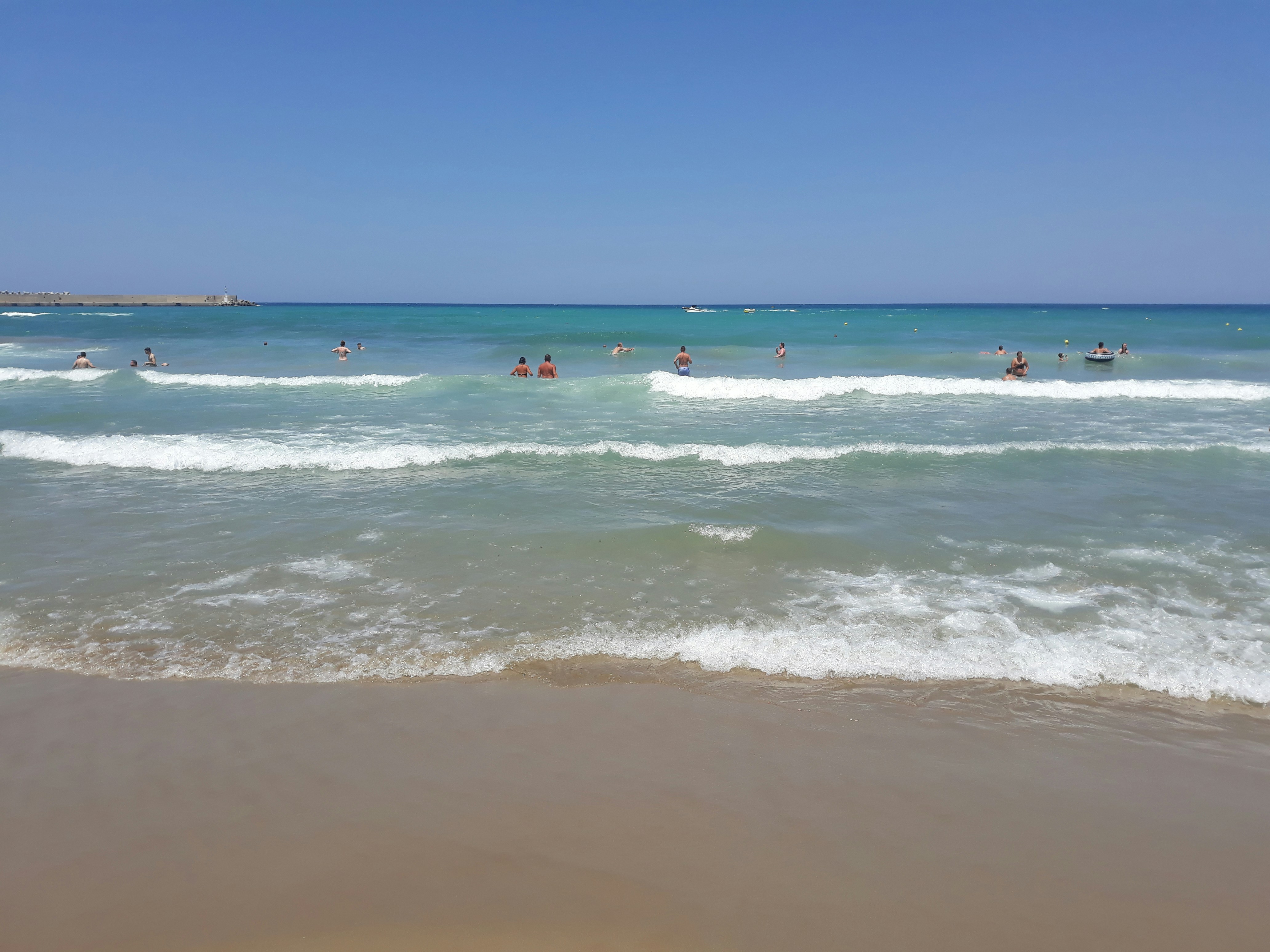 people swimming at the beach during daytime, Rethymno is a city on the north coast of the Greek Island Crete. Rethymno combines rarely united feature the old town