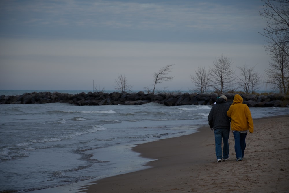 two person walking on shore