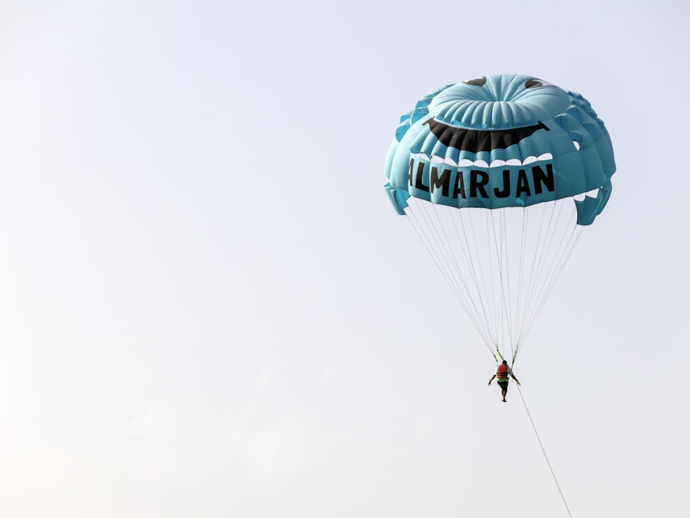 person in mid air doing paragliding at daytime