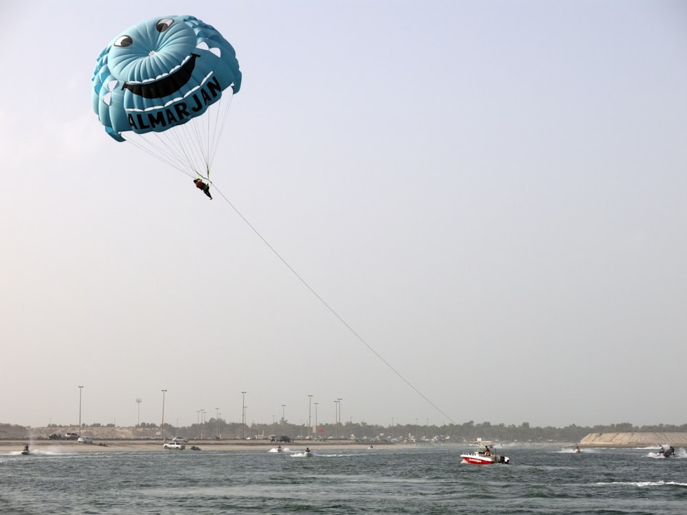 person riding blue parasailing