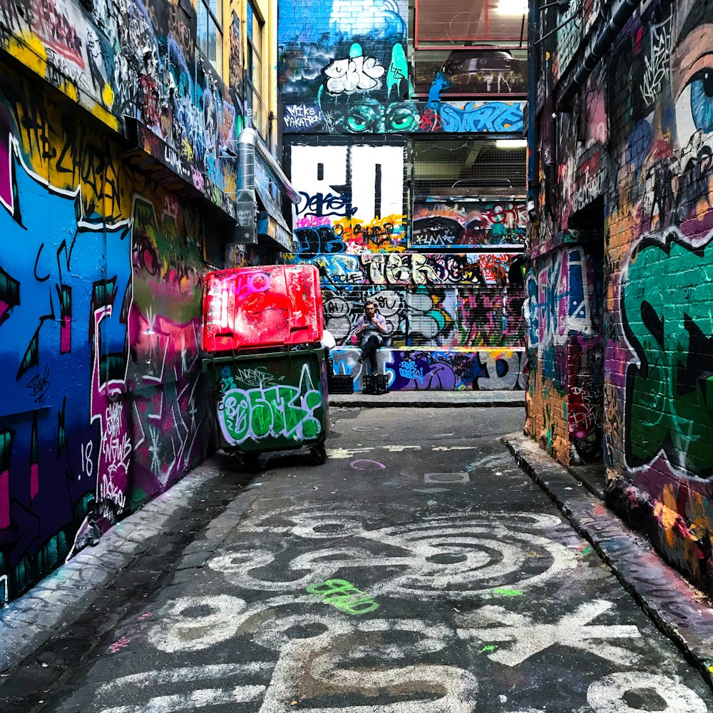 empty pathway between walls with graffitis