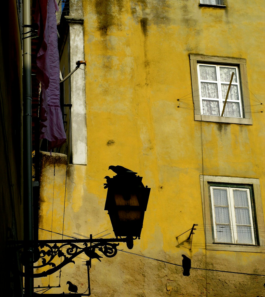 two closed windows on yellow building