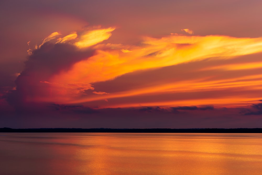 body of water under cloudy sky during golden hour