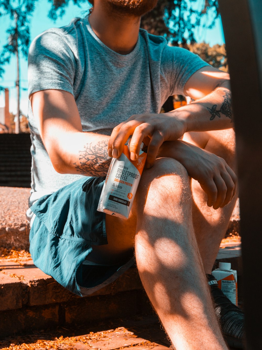 man wearing gray crew-neck shirt holding white and orange box