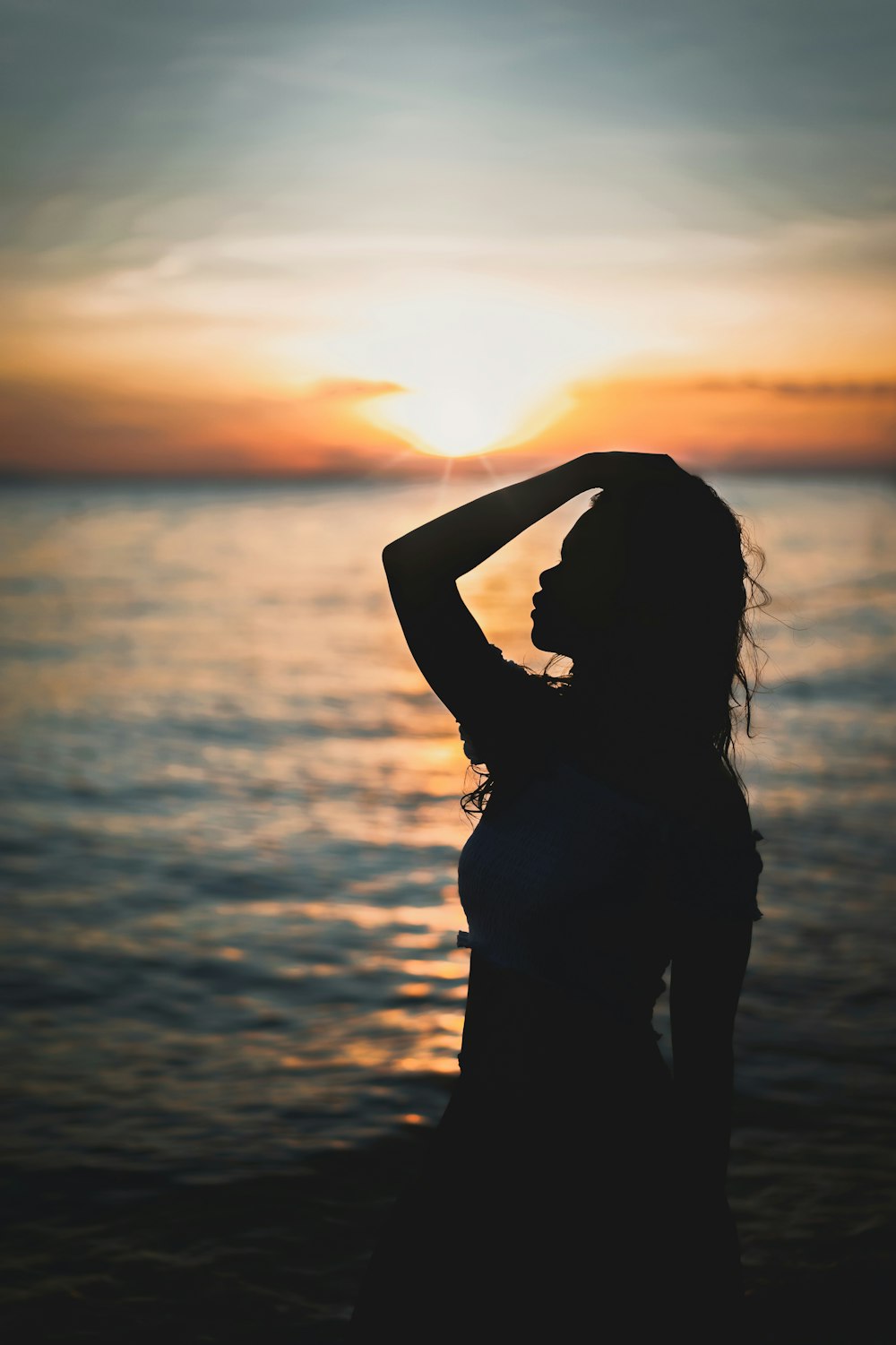 silhouette view of woman at the beach during golden hour