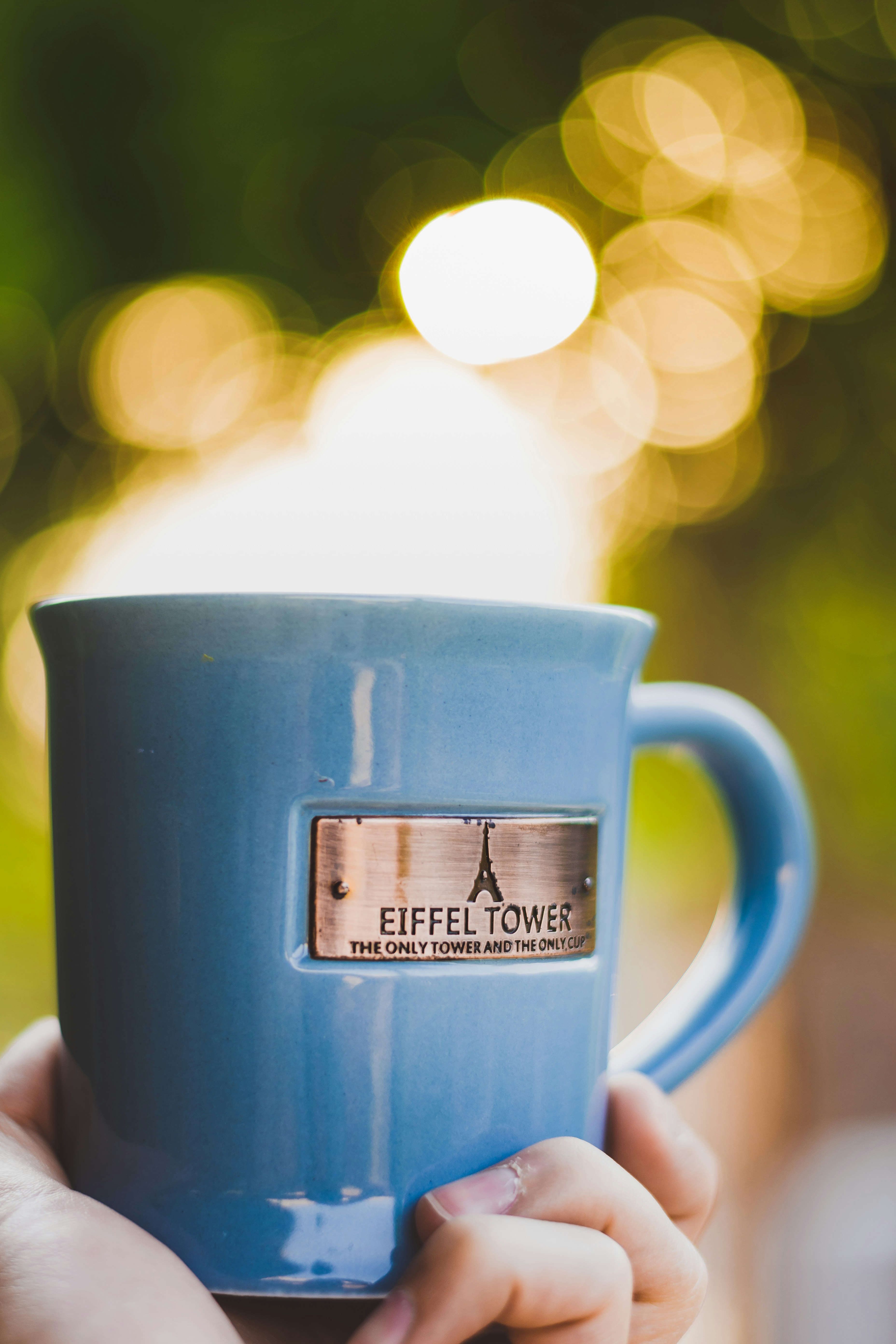 person holding blue ceramic mug