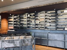 assorted bottles displayed on gray stainless steel shelf