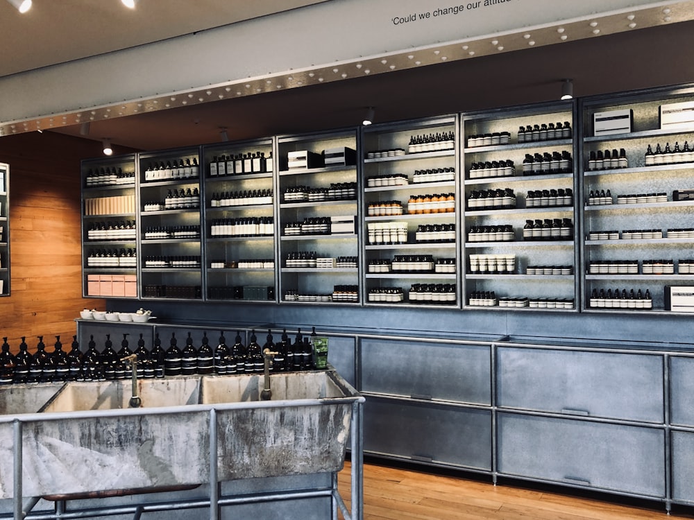 assorted bottles displayed on gray stainless steel shelf