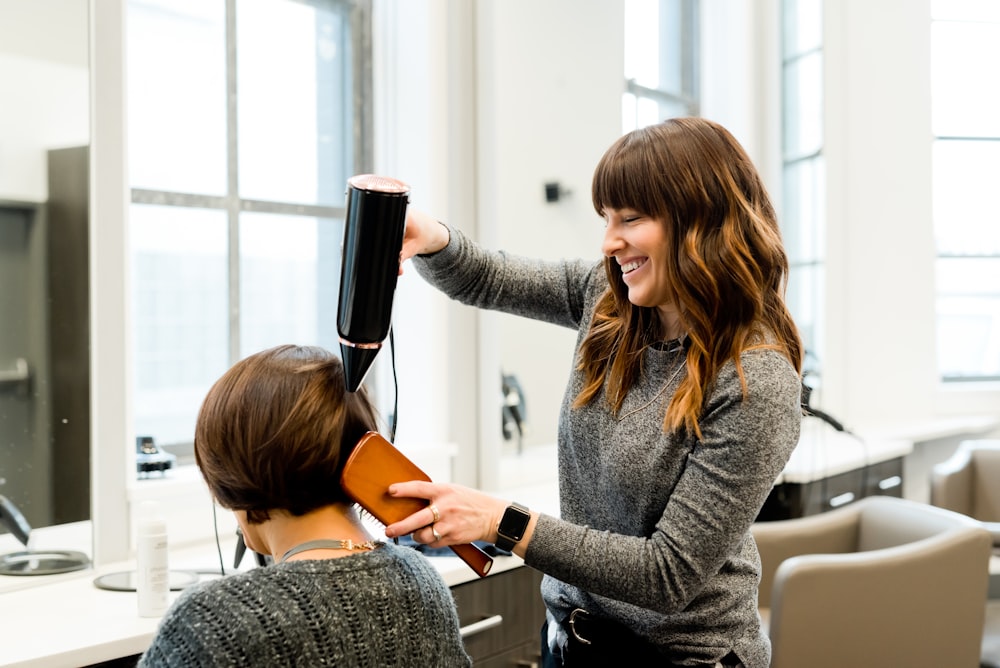 mujer sosteniendo secador de pelo