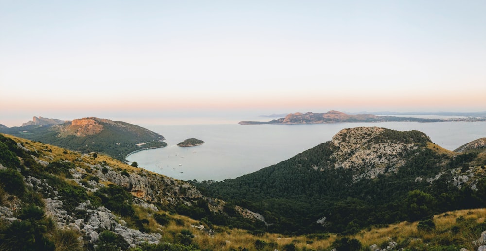 mountain beside body of water during daytime