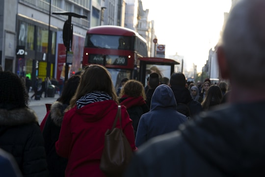 A bustling London street with diverse UK professionals discussing marketing ideas outdoors.
