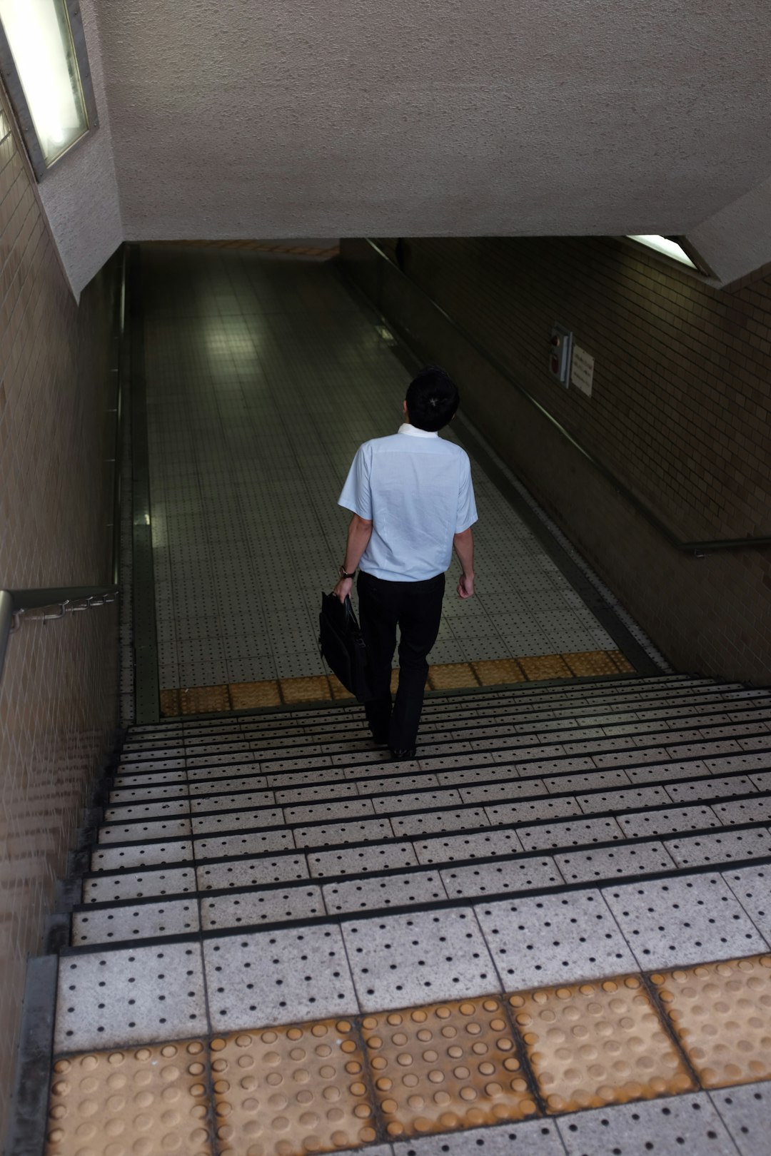 man holding bag walking down stairs