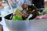 Close-up of a colorful salad with fresh vegetables on a rustic wooden table.