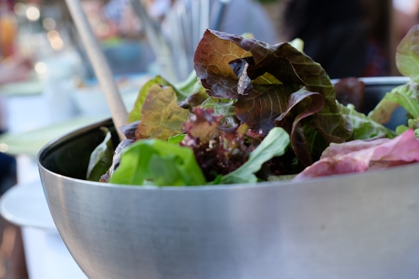 A close-up of a fresh, colorful salad bowl on a rustic wooden table.