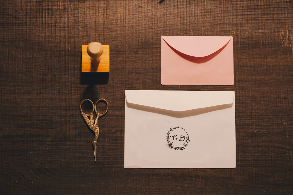 a pair of scissors, a rubber stamp, and a card on a table