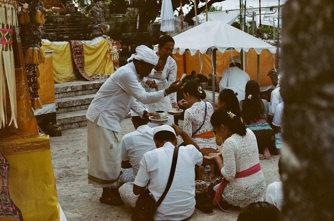 people sitting on ground beside trees during daytime