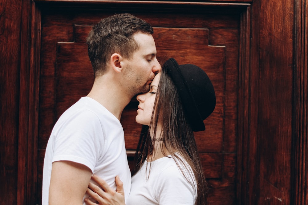 man kissing woman forehead