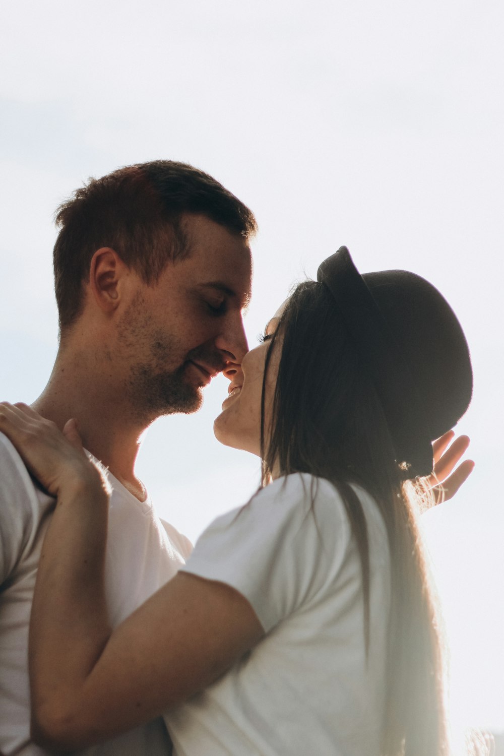 couple wearing white shirts touching their noses